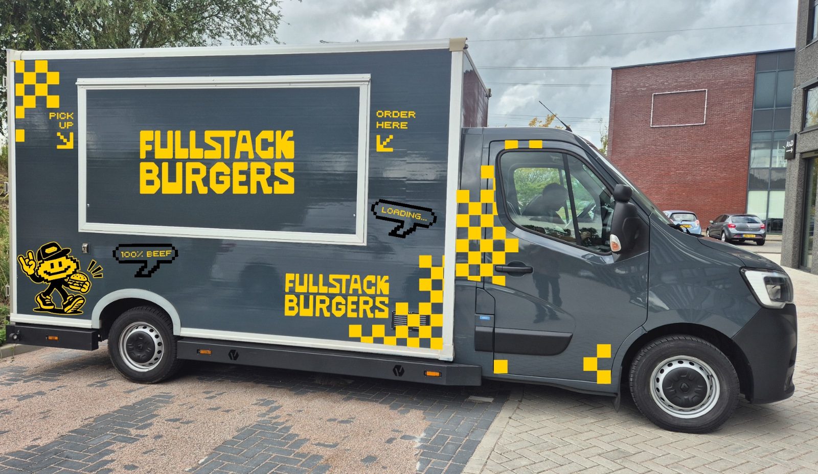 De originele Fullstack Burgers-foodtruck met gele belettering en pixelpatronen, volledig in beeld.